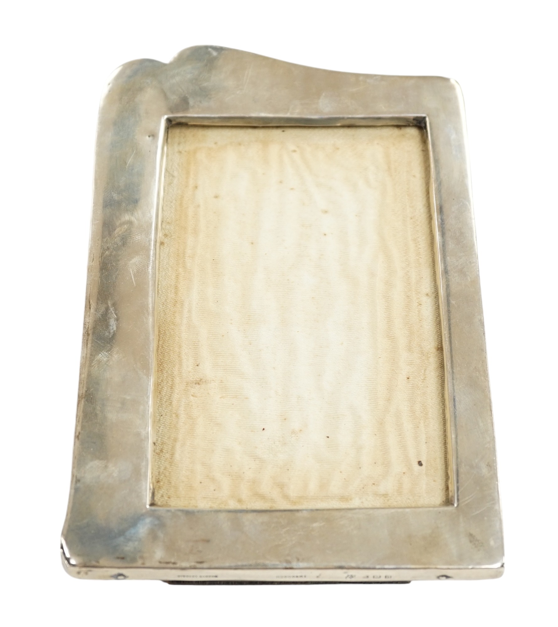 A George V silver mounted shaped photograph frame, Birmingham, 1912, 19.8cm. Condition - poor